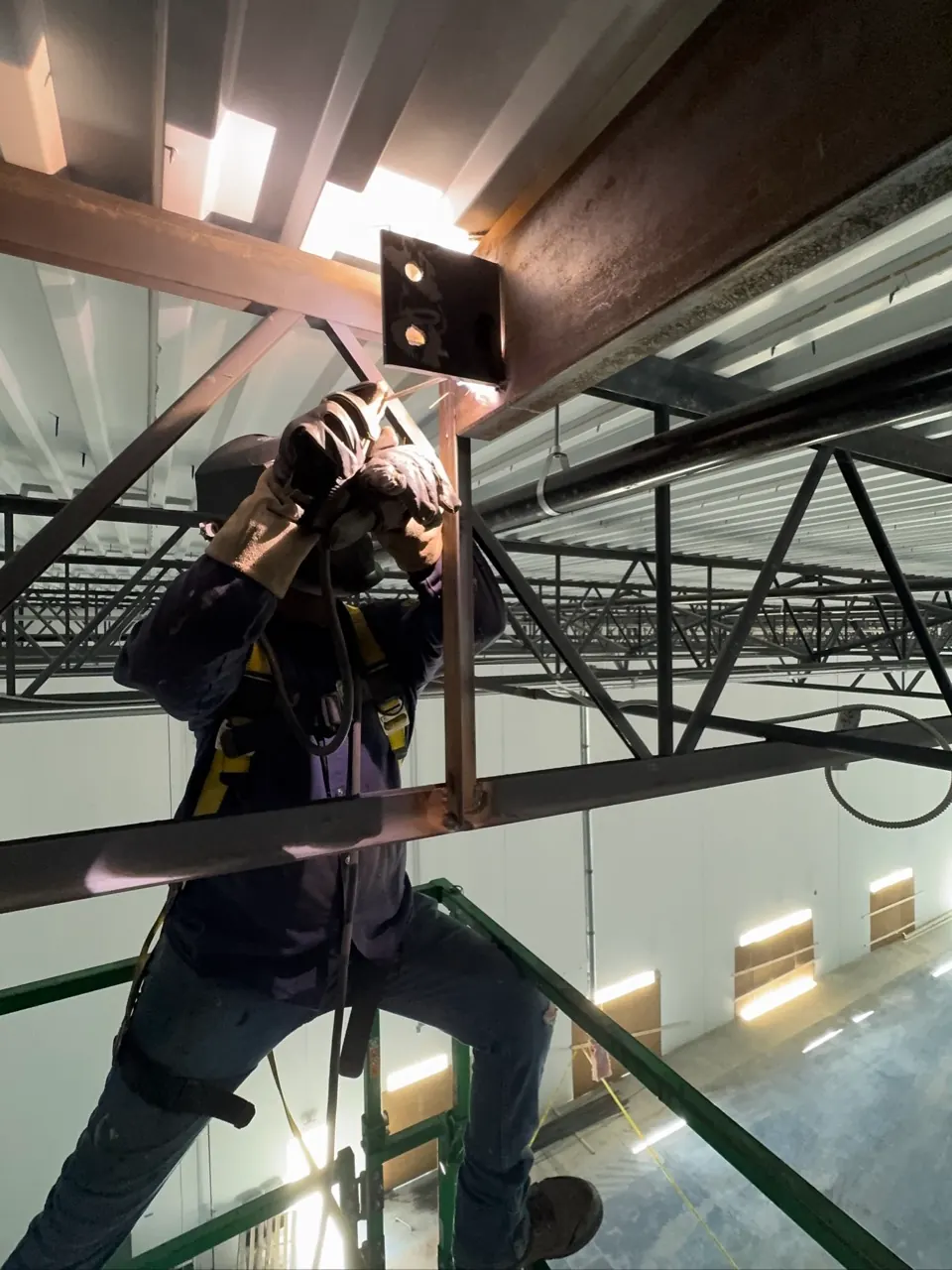 Welder repairing a structural frame connection